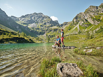 Pärchen steht vor dem Bergsee Moaralmsee.